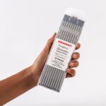 Hand holding of ten Weldcraft 4.0mm (5/32 inch) gray 2% ceriated tungsten electrodes for TIG welding, ground finish.